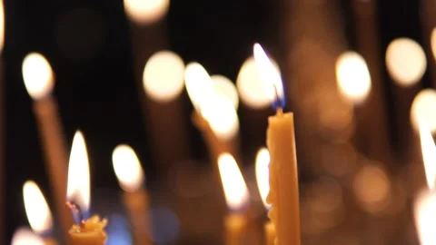 Illuminated candles in a dark setting provide warm glowing light creating a Stock Footage 277536867