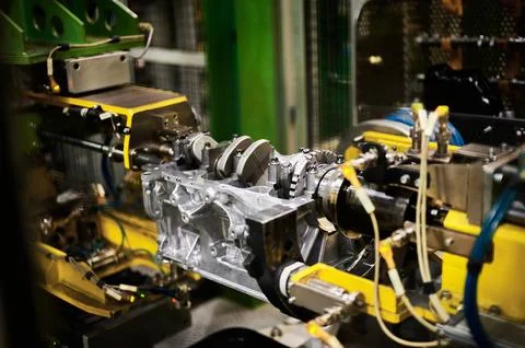 Illuminated car engine on test stand in production plant shop Stock Photos