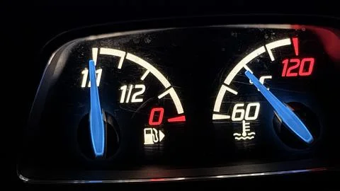 Illuminated car instrument panel at night showing fuel and temperature analog Stock Photos