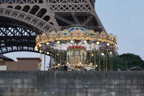 Illuminated carousel in front of the Eiffel Tower after sunset. Stock Photos