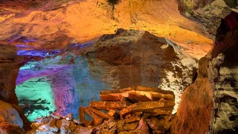 Illuminated Cave Interior with Multicolor Lights on Rock Formations Stock Photos