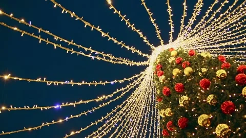 Illuminated christmas tree with cascading string lights at night Stock Footage 323208995