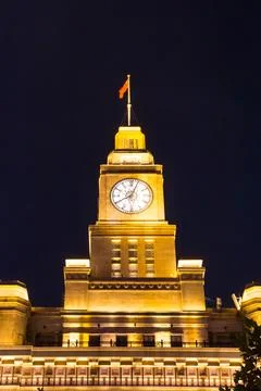 Illuminated clock tower on the custom building in Shanghai Stock Photos
