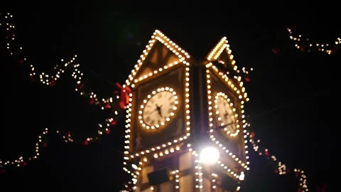 Illuminated clock tower with festive lights at night Stock Footage 166664496