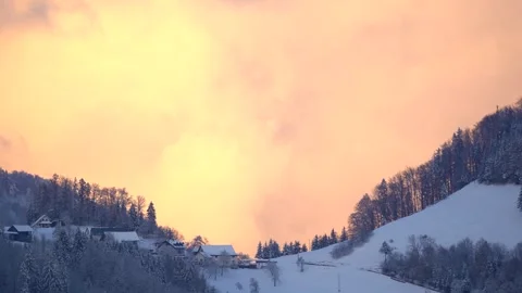 Illuminated clouds moving over an idyllic village in Slovenia Stock Footage 293563716