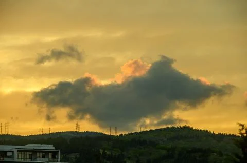 Illuminated clouds in a serene, dramatic outdoor landscape with trees and p.. Foto stock
