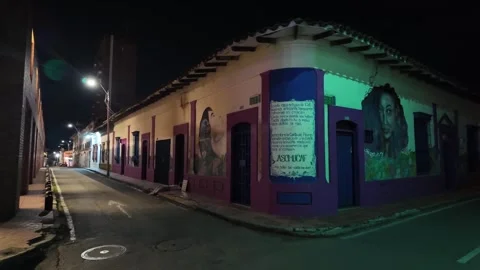 Illuminated colonial corner building with artistic murals at night in San Stock Footage 336703189