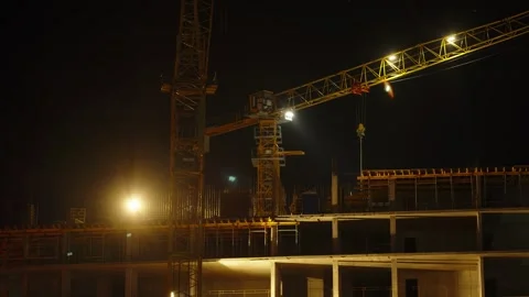 Illuminated construction crane operating at night on a building site. Stock Footage 342371898