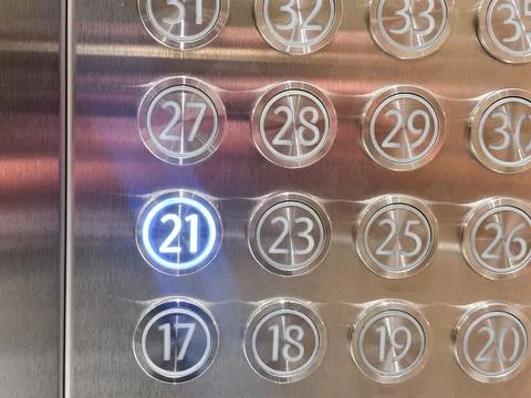 Illuminated elevator floor button number 21 glowing in a metal control panel Stock Photos