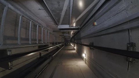 In an illuminated elevator shaft, the cabin moves down.  Stock-Footage 88416211