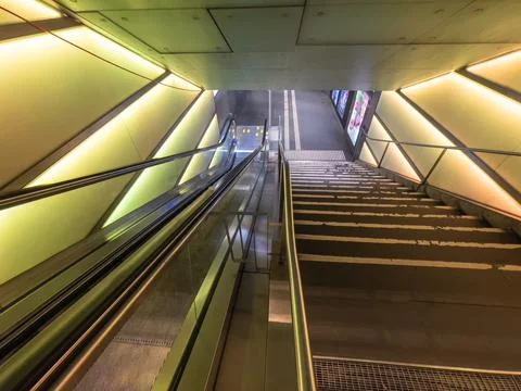 Illuminated escalator to the railway station area Stock Photos