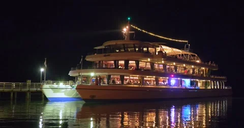 Illuminated excursion boat at night entering the port of Starnberg on Lake .. Video stock 248605091