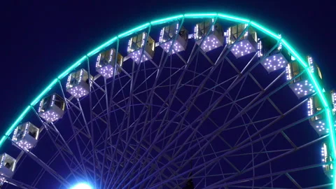 Illuminated ferris wheel rotates Stock Footage 109262979