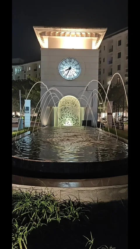 Illuminated Fountain Elegance | Arched Streams &amp; Majestic Watch Tower Nightscape Stock Footage 324520114