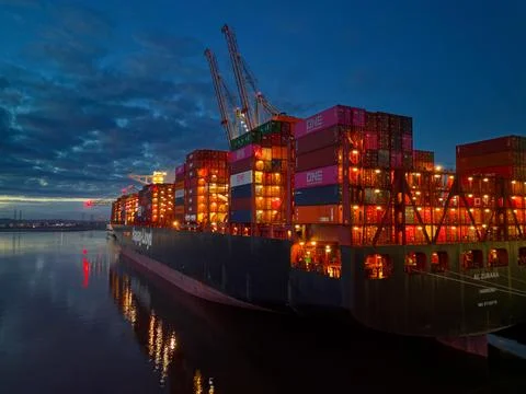 Illuminated Hapag-Lloyd container ship at dusk at Southampton Docks aerial Stock Photos