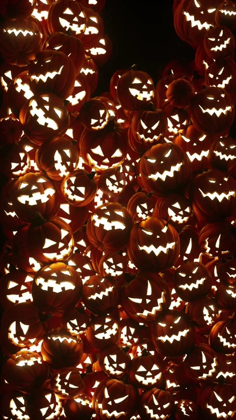Illuminated Jack-o-lanterns pumpkins fill the screen as they fall Stock Footage 345523248