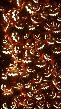 Illuminated Jack-o-lanterns Pumpkins with carved faces fill the screen 스톡 사진