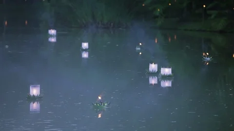 Illuminated lanterns floating down river Stock Footage 97103396
