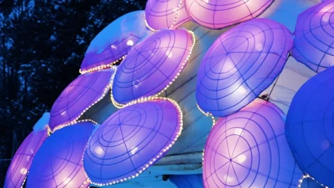 Illuminated lanterns in the shape of a jellyfish in a winter park setting.  Video stock 326163625