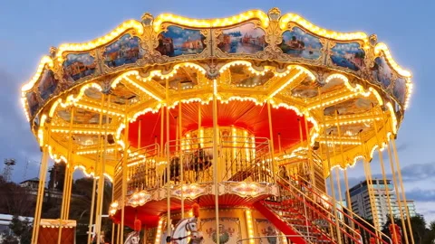 Illuminated merry go round carousel filmed at dusk in amusement park. Stock Footage 236286021