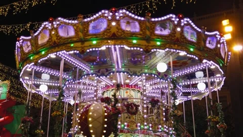 Illuminated merry go round carousel filmed at night in amusement park. Stock Footage 312668756