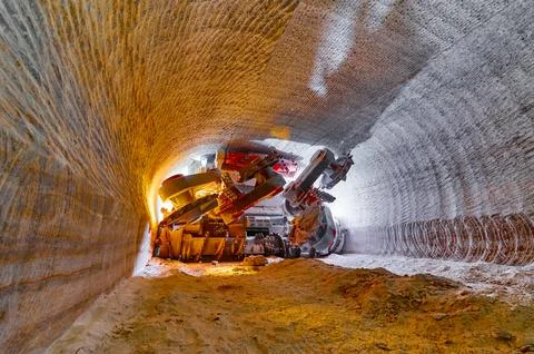 Illuminated mining drilling machine in salt quarry tunnel Stock Photos