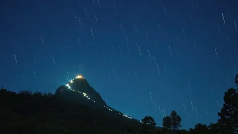 Illuminated mountain peak and star trails Stock Footage 175333166
