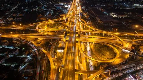 Illuminated Multi-level Highway Interchange With Flowing Traffic Light Trai.. 写真素材