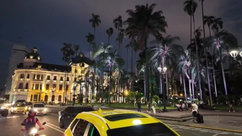 Illuminated neoclassical Edificio Otero in Plaza de Caicedo with passing yellow Stock Footage 336303406