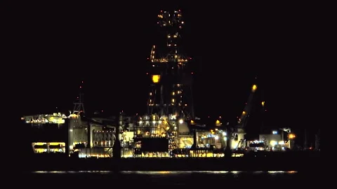 Illuminated offshore oil platform operates at night on a dark sea - Night Rig Stock Footage 339946261