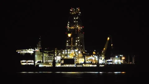 Illuminated offshore oil platform operates at night on a dark sea - Marine Plant Stock Footage 339946295