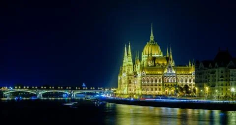 Illuminated Parliament building on the Danube River at night in Budapest, Stock Photos