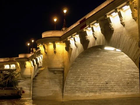 Illuminated stone bridge at night, reflected in the water below, Paris, Seine, Stock Photos