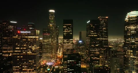 Illuminated streets downtown Los Angeles skyline at twilight dusk night. Aerial Stock Footage 256281953