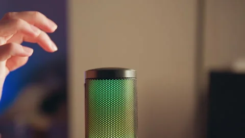 Illuminated studio microphone with hand reaching toward top grille during Stock Footage 343542110