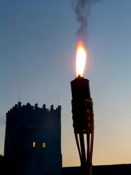Illuminated Torch by the Lutsk Castle Tower at Night, Showcasing Historical.. Stock Photos