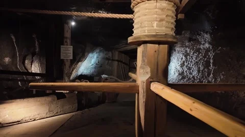 Illuminated underground chambers show mining equipment and wooden structures in Stock Footage 334719370