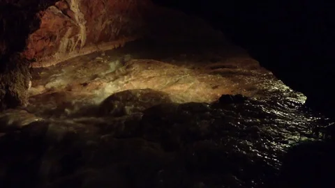 Illuminated Underground River in a Dark Red Cave Qızıl Qoba , Crimea , Russia Stockbeeldmateriaal 82299077