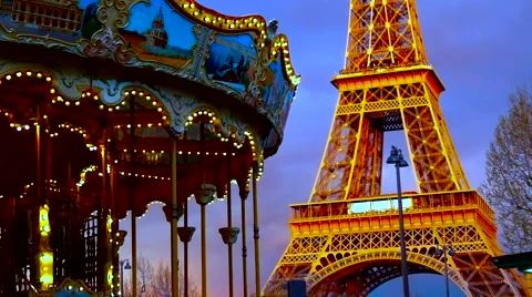Illuminated vintage carousel rotates in front of illuminated Eiffel Tower, Paris Stock Footage 62810845