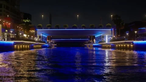 Illuminated waterfront bridge spanning harbor at night with blue neon lightin Stock Footage 337478623