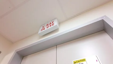 Illuminated X-Ray In Use sign above radiation room doors Stock Footage 331968324