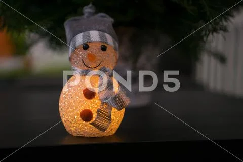 Illuminating snowman decoration in a hat and scarf Stock Photos