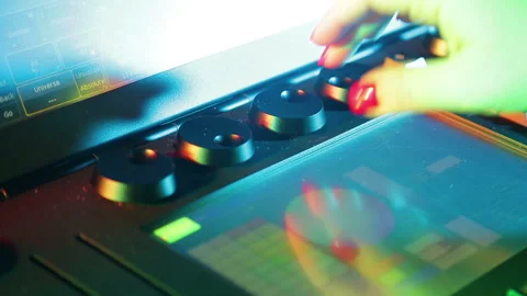 The illuminator's hand sets up the mixing light console and prescribes programs Vidéo 121336054