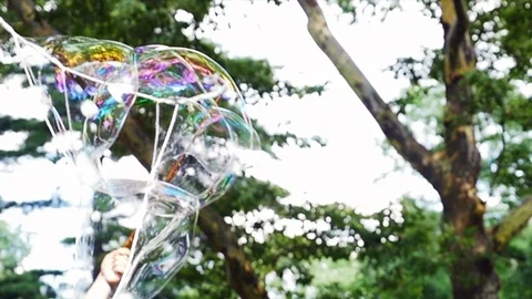Illusionist blows big soap bubbles in the city park. Stock Footage 93798192