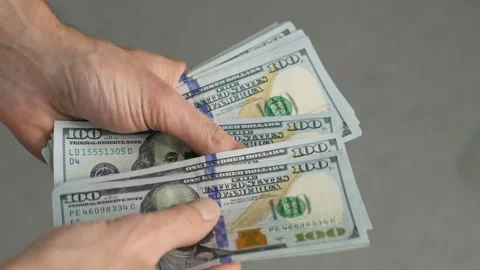 In the illustration, hands are seen counting stacks of hundreddollar bills Video stock 277932368