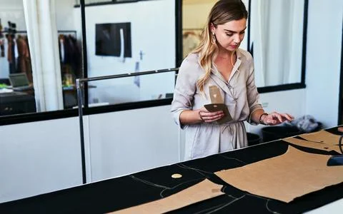 Im about to start the cutting process. a young fashion designer working working Stock Photos