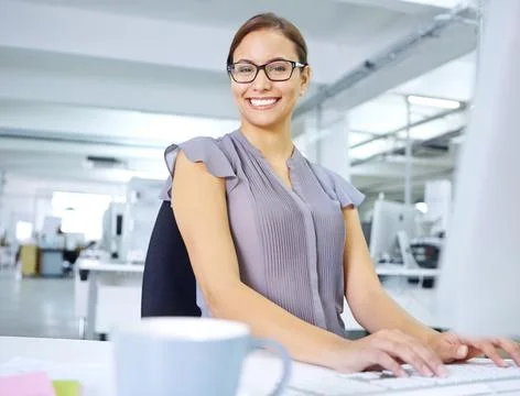 Im all about efficiency. an attractive young office worker sitting at her desk Stock Photos
