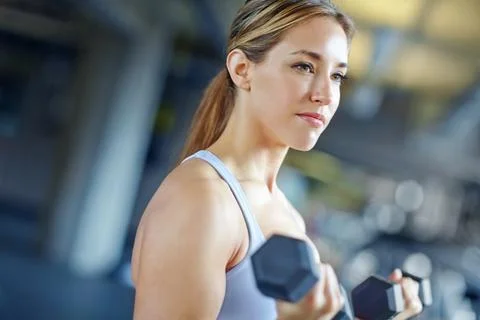 Im making great progress. A beautiful young woman working out at the gym. Foto stock