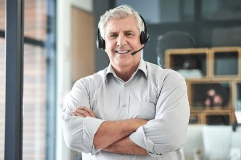 Im ready to make a difference. Shot of a mature call centre agent standing alone Stock Photos