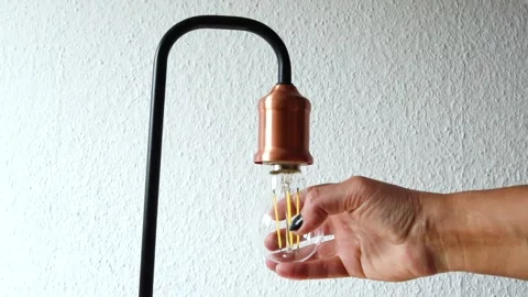 I'm screwing in a new light bulb. I'm unscrewing a glass light bulb.  Stock Footage 275197051